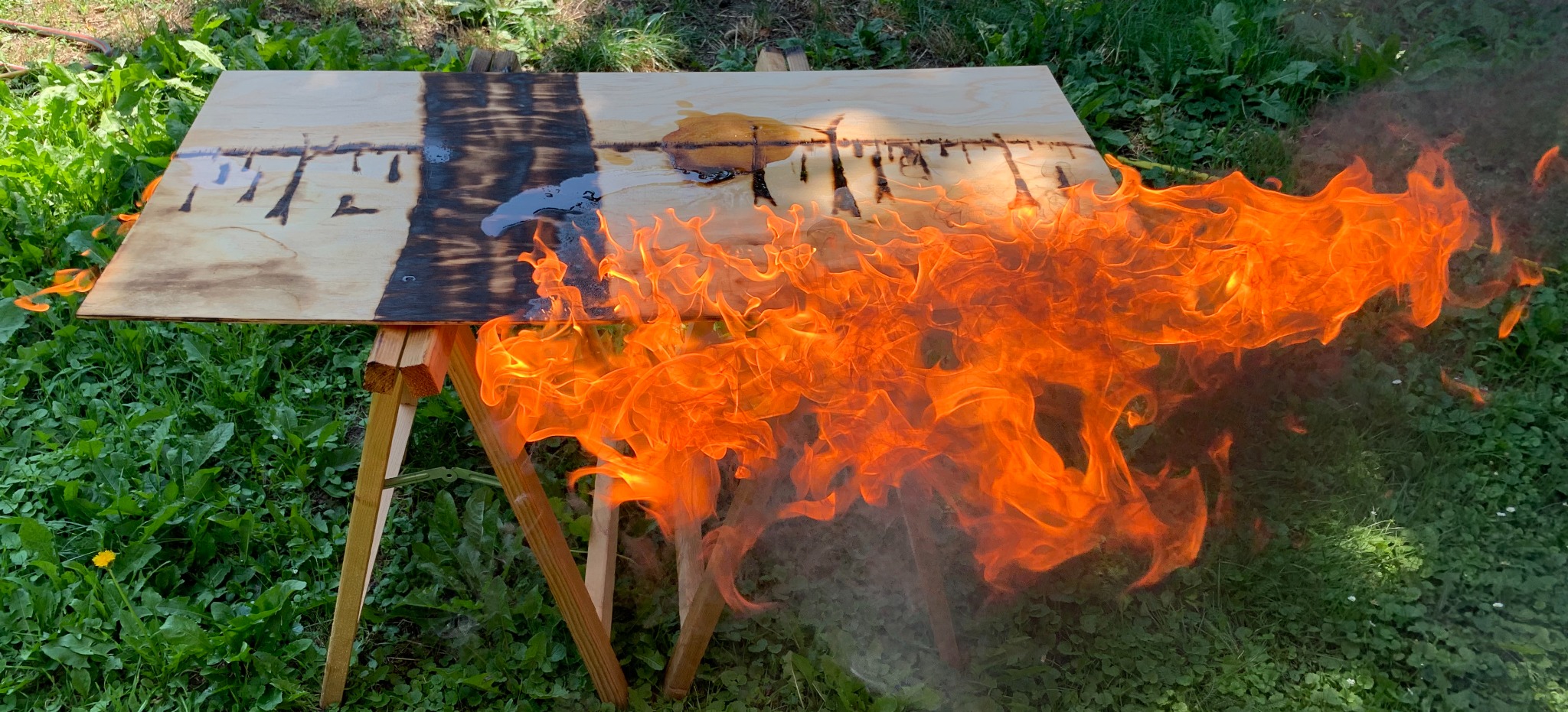 Flammen auf einer Holzplatte während der Entstehung einer Firescape-Arbeit